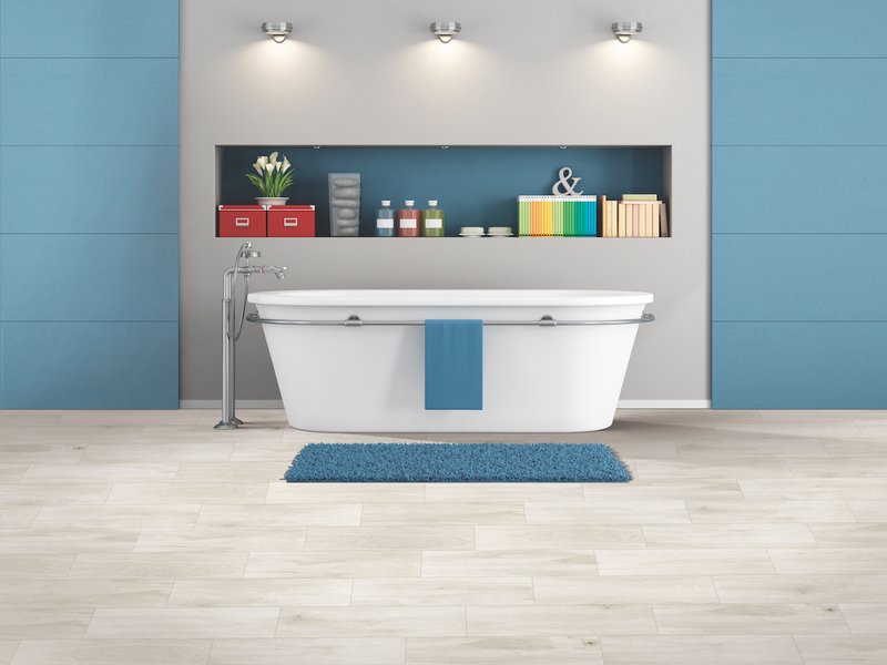 Modern spacious bathroom with free standing bathtub and blue mat