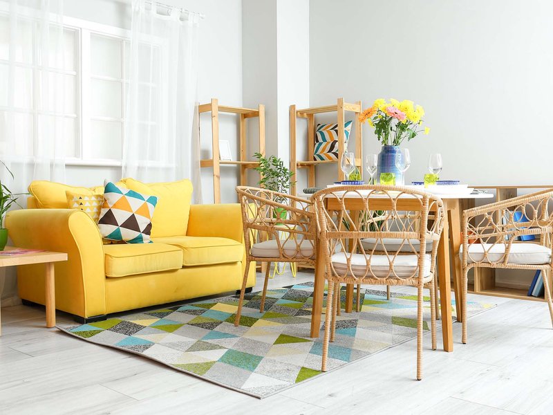 yellow couch on a color patterned are rug from Christie Carpets Flooring & Blinds in Rochester, NY